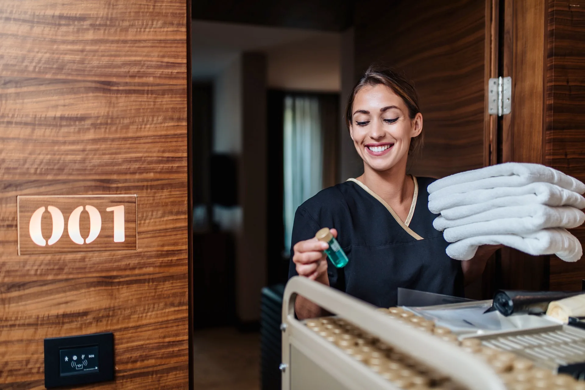 Femme de chambre préparant une chambre d'hôtel avec minutie